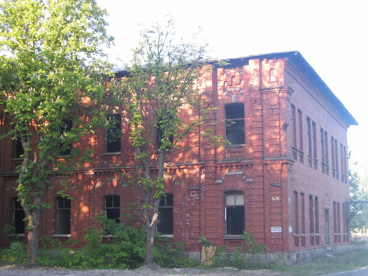An abandoned brick building with broken windows