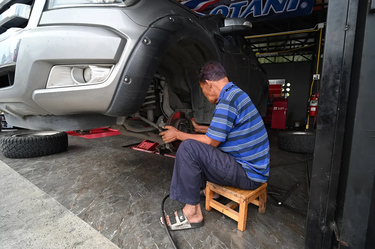 A mechanic working on a car wheel in a repair shop