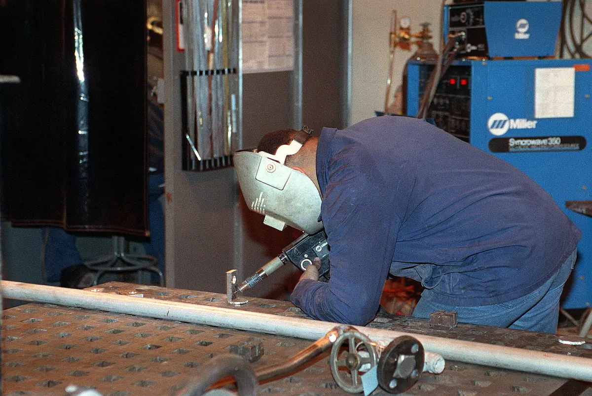 A worker welding in an industrial shop